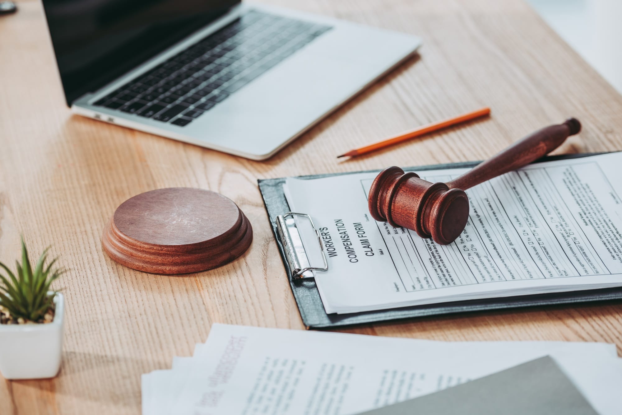 clipboard with compensation claim form and gavel lying over on the office desk, compensation concept